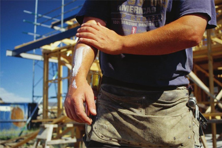 Guide to ensuring worker safety outdoors - builder applying sun cream